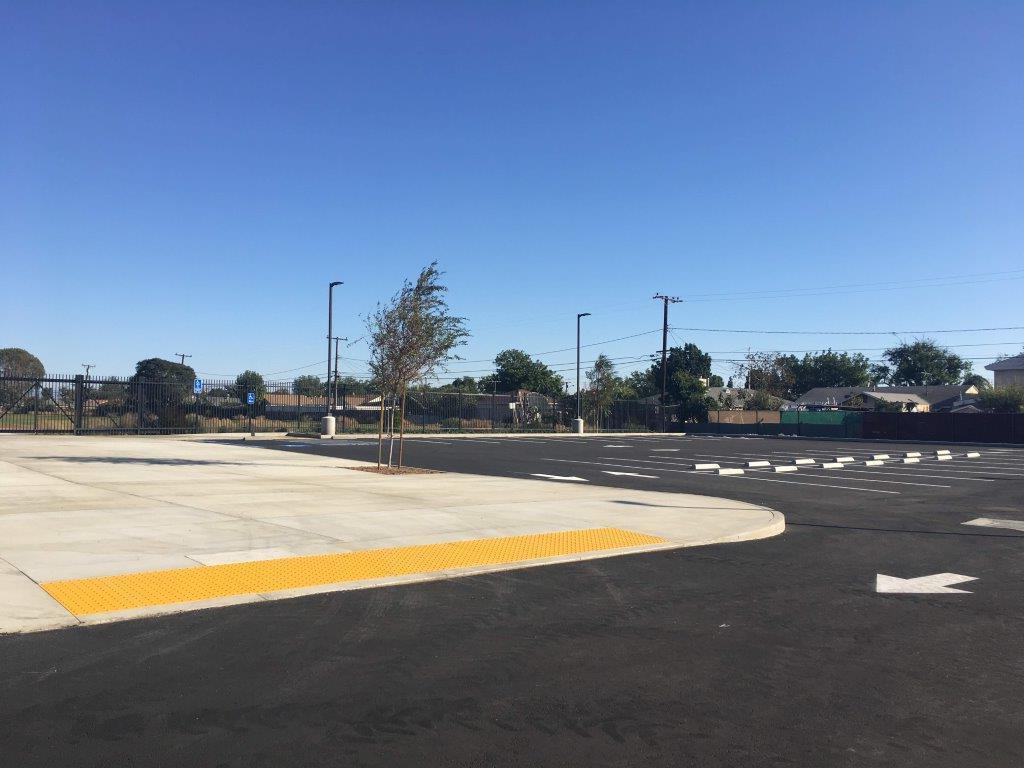 A newly paved parking lot under a clear blue sky.