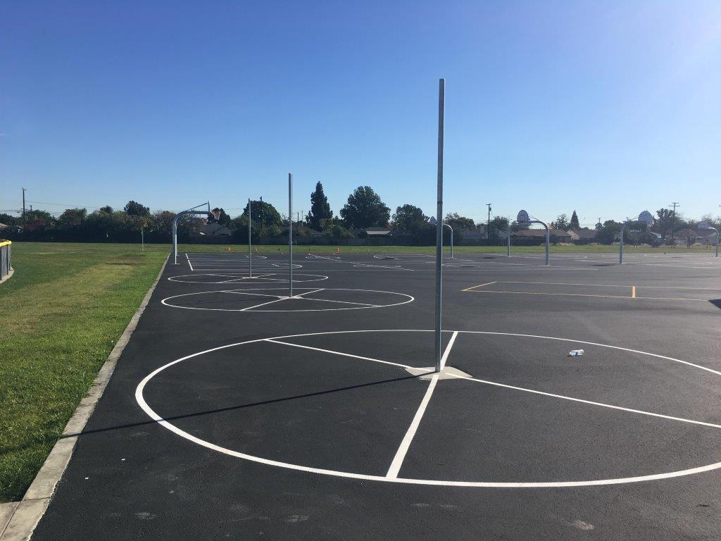 Empty outdoor basketball courts under a clear blue sky.