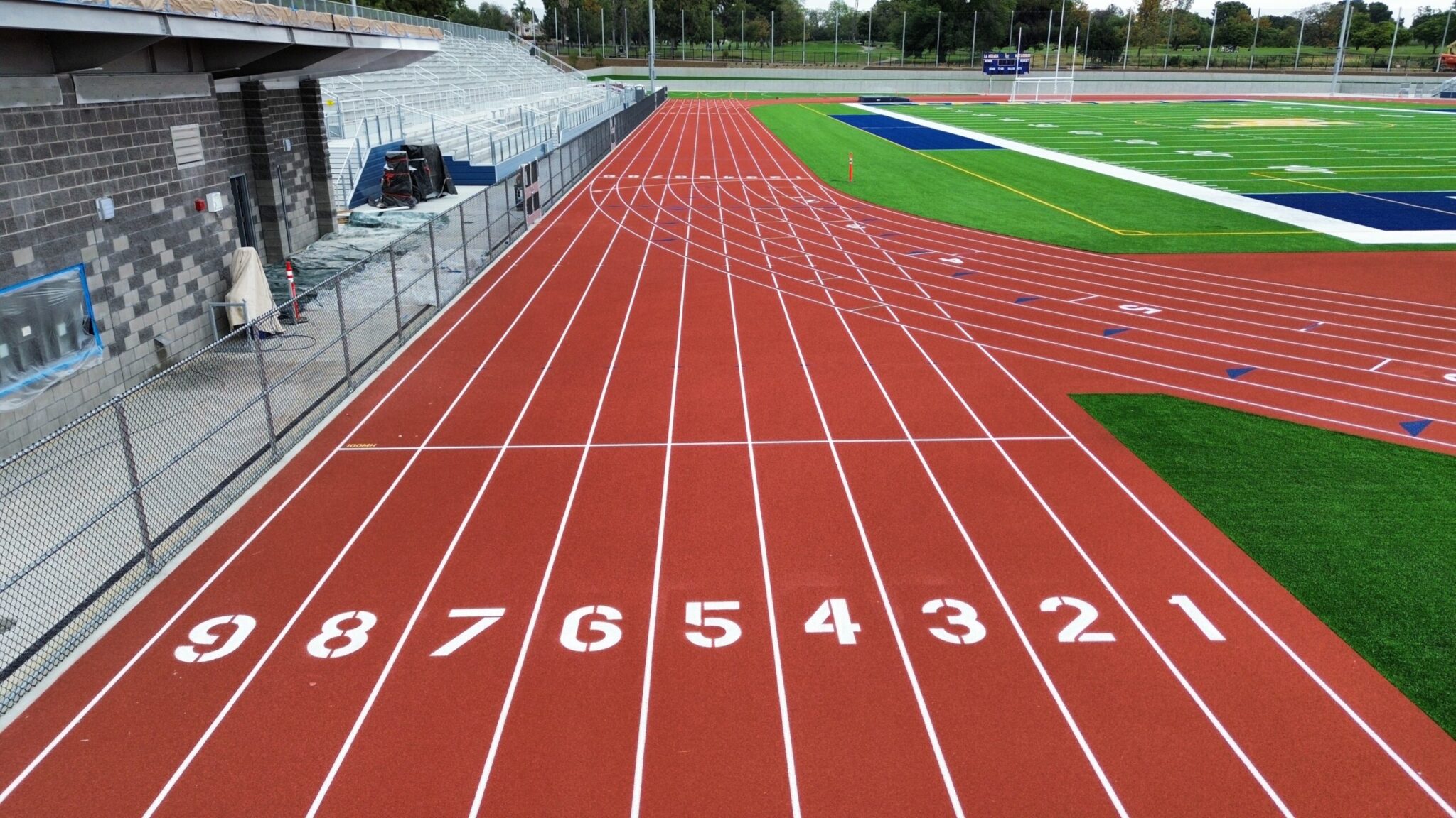Empty running track lanes numbered 1 to 8 at a sports field.