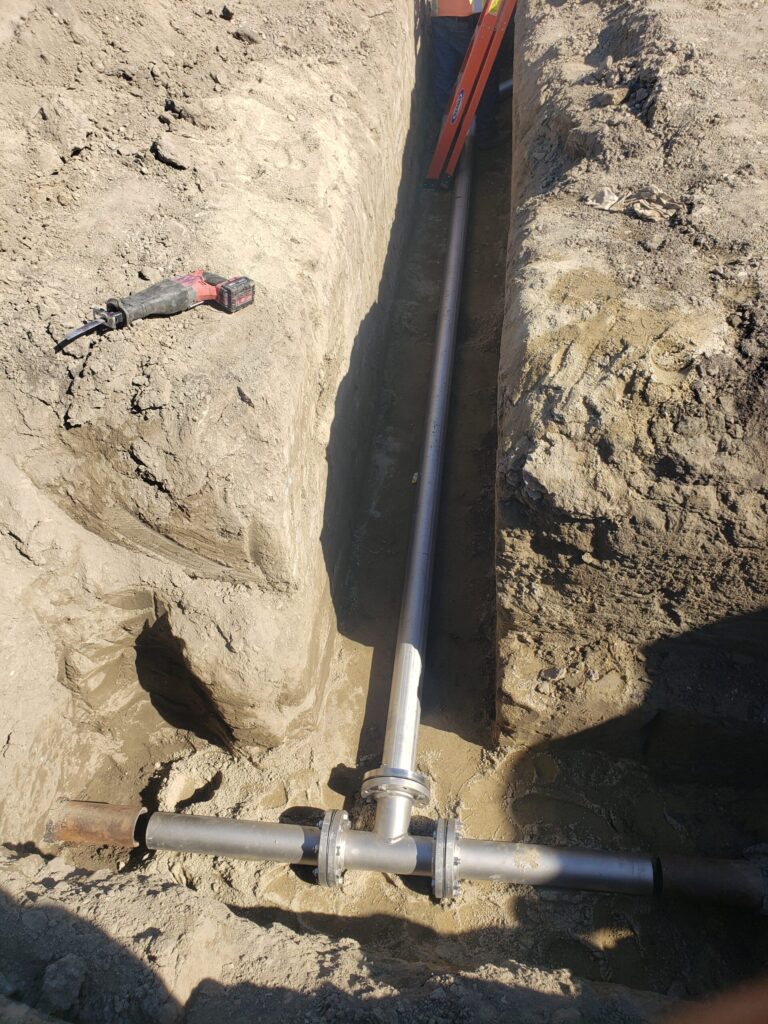 Newly installed underground pipe in a trench.