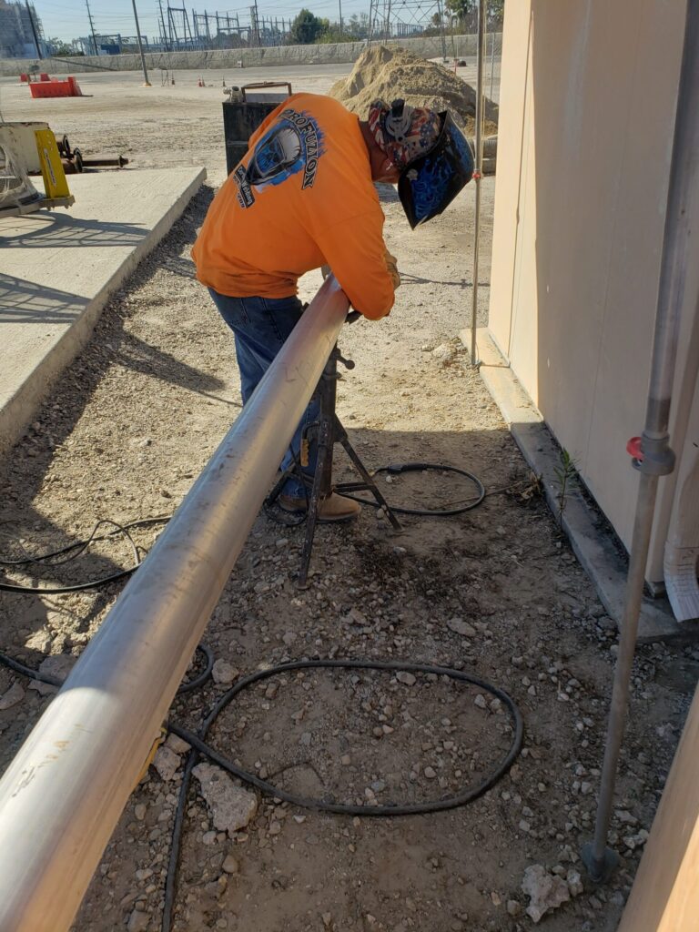 Long metal pipe on a tripod outdoors near a building.