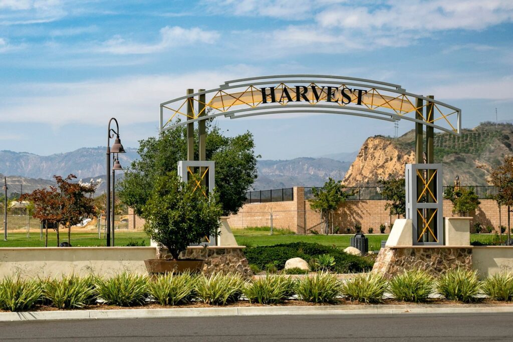 Entrance sign reading 'Harvest' with a scenic mountain backdrop.