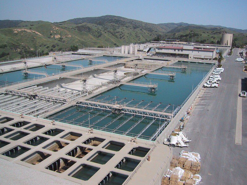 Large water treatment facility with multiple pools and machinery.