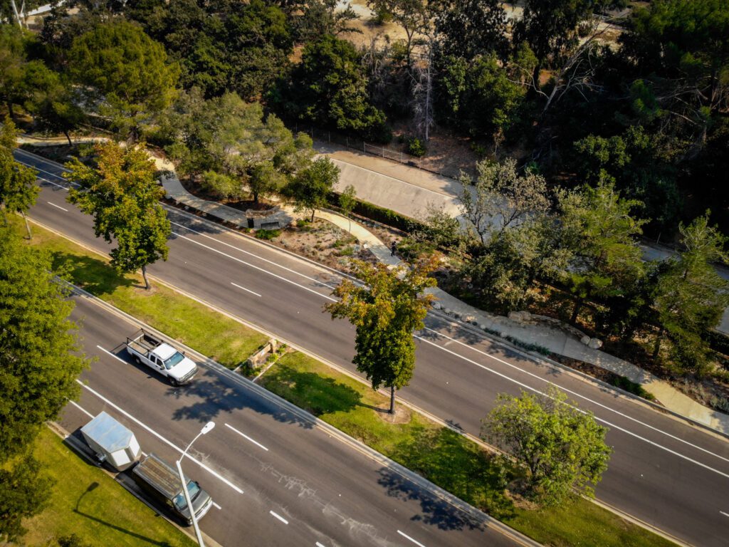 Aerial view of a road with vehicles and greenery.