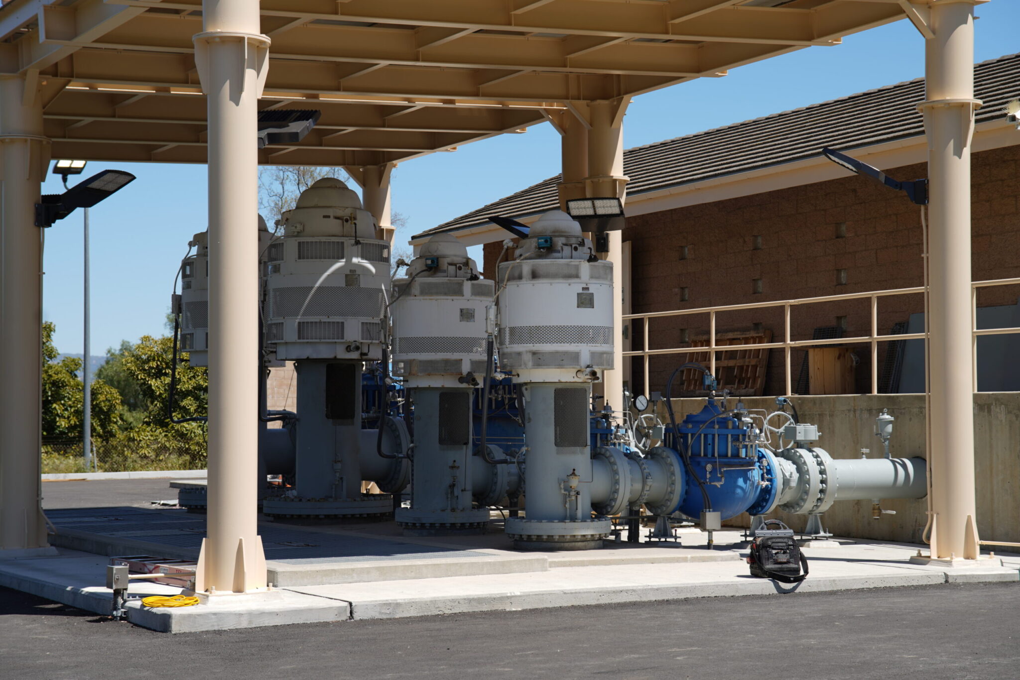 Industrial pumps and equipment under a shelter outdoors.