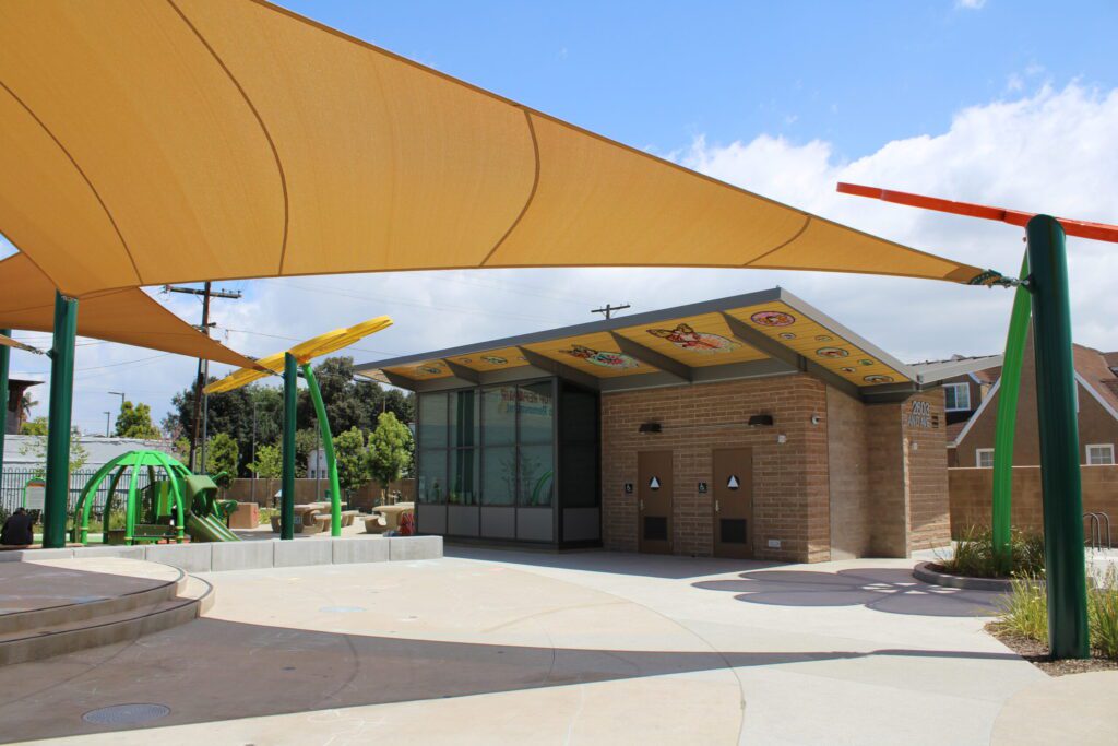 Entrance area with shade sails and brick walls on a sunny day.