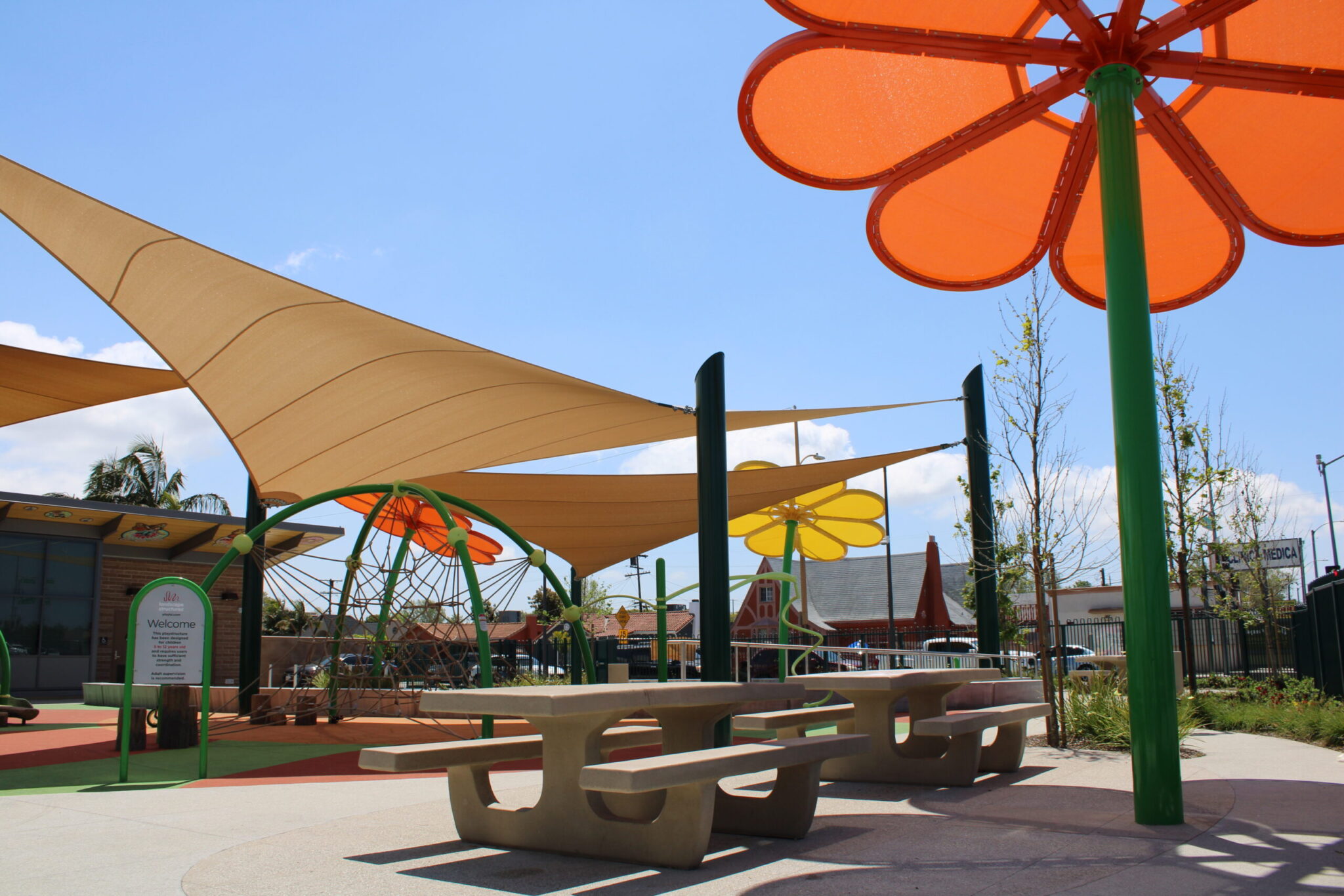 Colorful outdoor seating area with shade structures and playful flower designs.