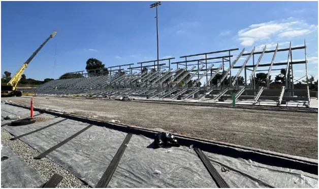 Empty outdoor bleachers under a clear blue sky.