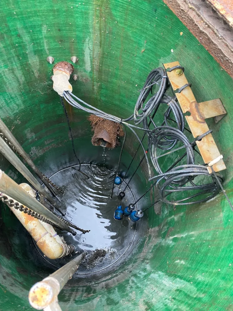 Workers performing maintenance inside a large green industrial tank.