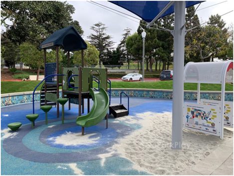 A colorful playground with slides and climbing structures under a blue sky.