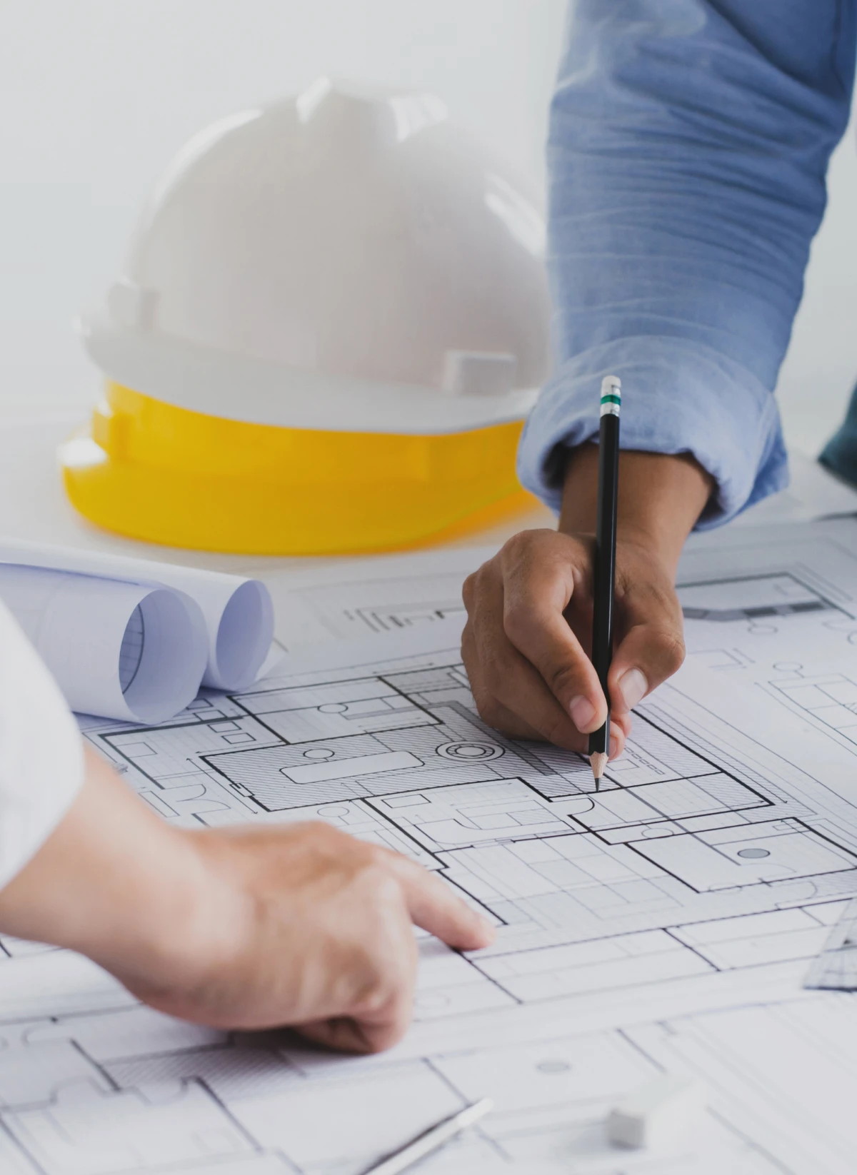 Architects reviewing blueprints with hard hat