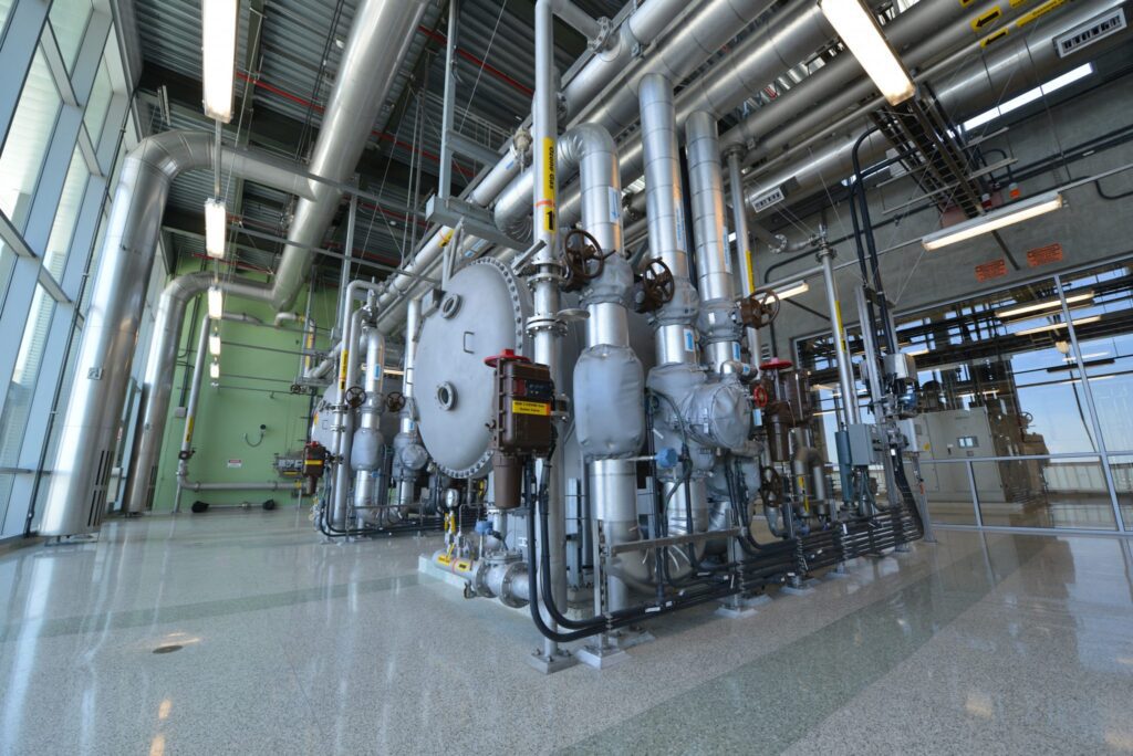Industrial machinery with pipes and tanks in a factory setting.