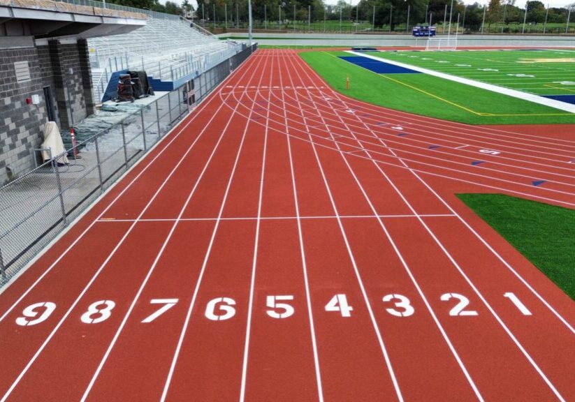 Empty running track lanes numbered 1 to 8 at a sports field.