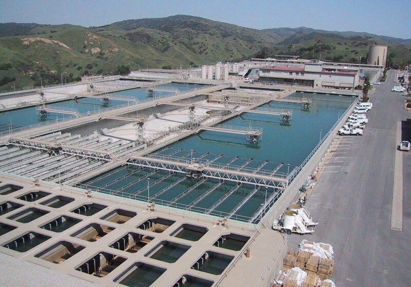 Large water treatment facility with multiple pools and machinery.