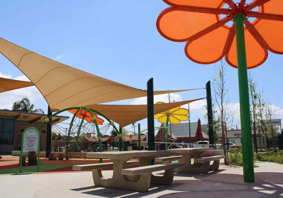 Colorful outdoor seating area with shade structures and playful flower designs.