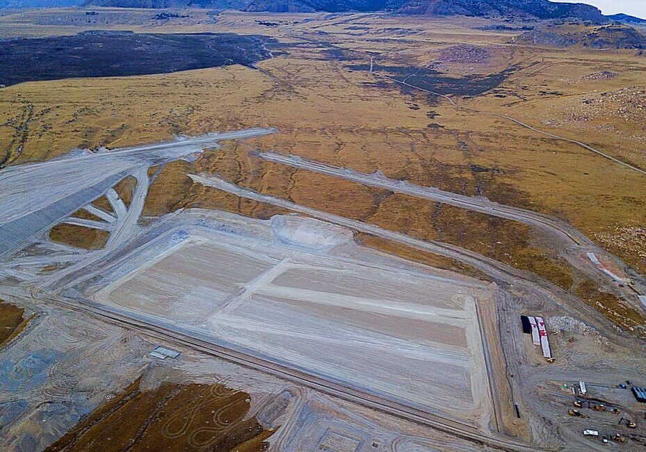 Aerial view of a large, rectangular excavation site in a barren landscape.