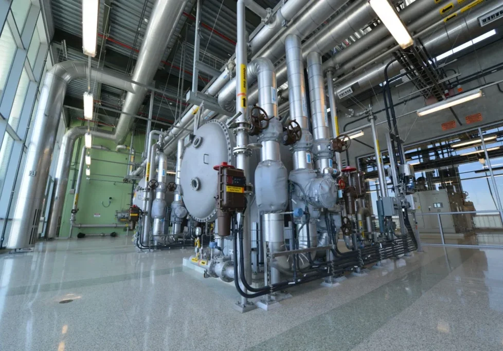 Industrial machinery with large pipes inside a factory.