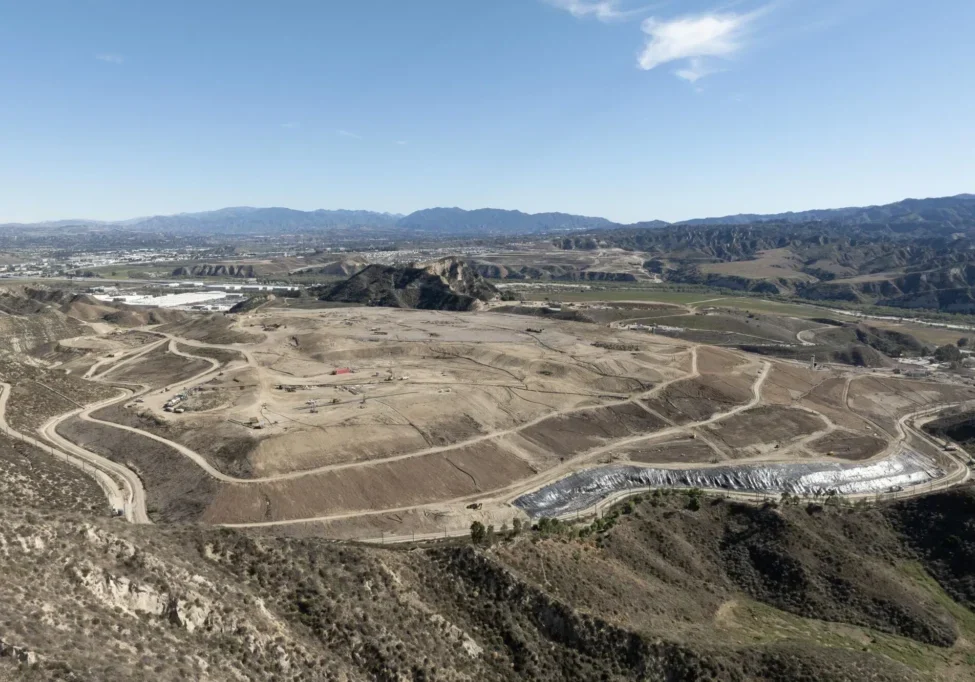 Vast open landscape with winding roads and distant mountains under a clear sky.